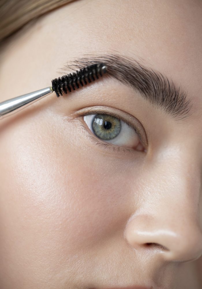 portrait-beautiful-woman-with-clear-skin-brushing-her-eyebrows